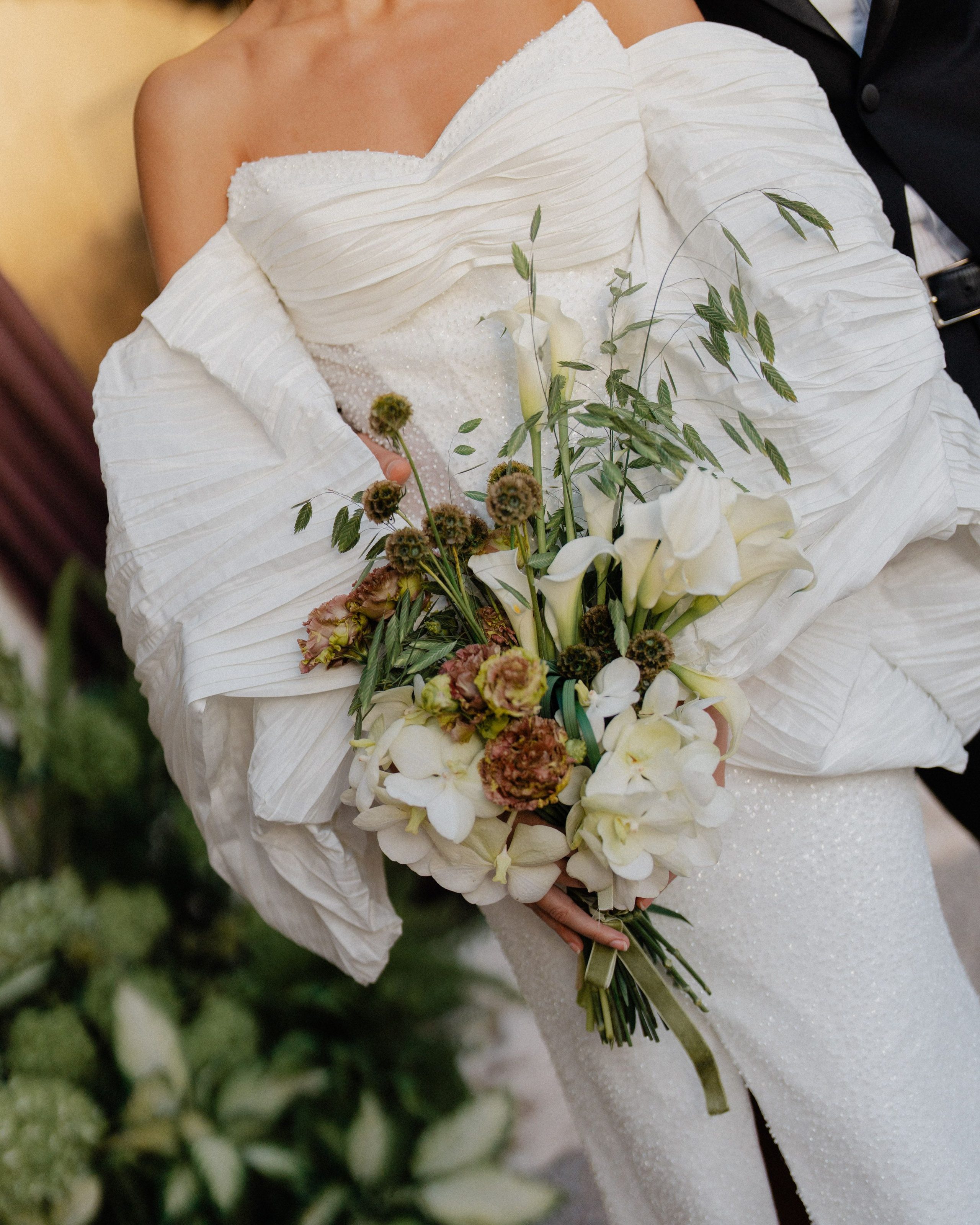 A loose bouquet of flowers and olive branches.