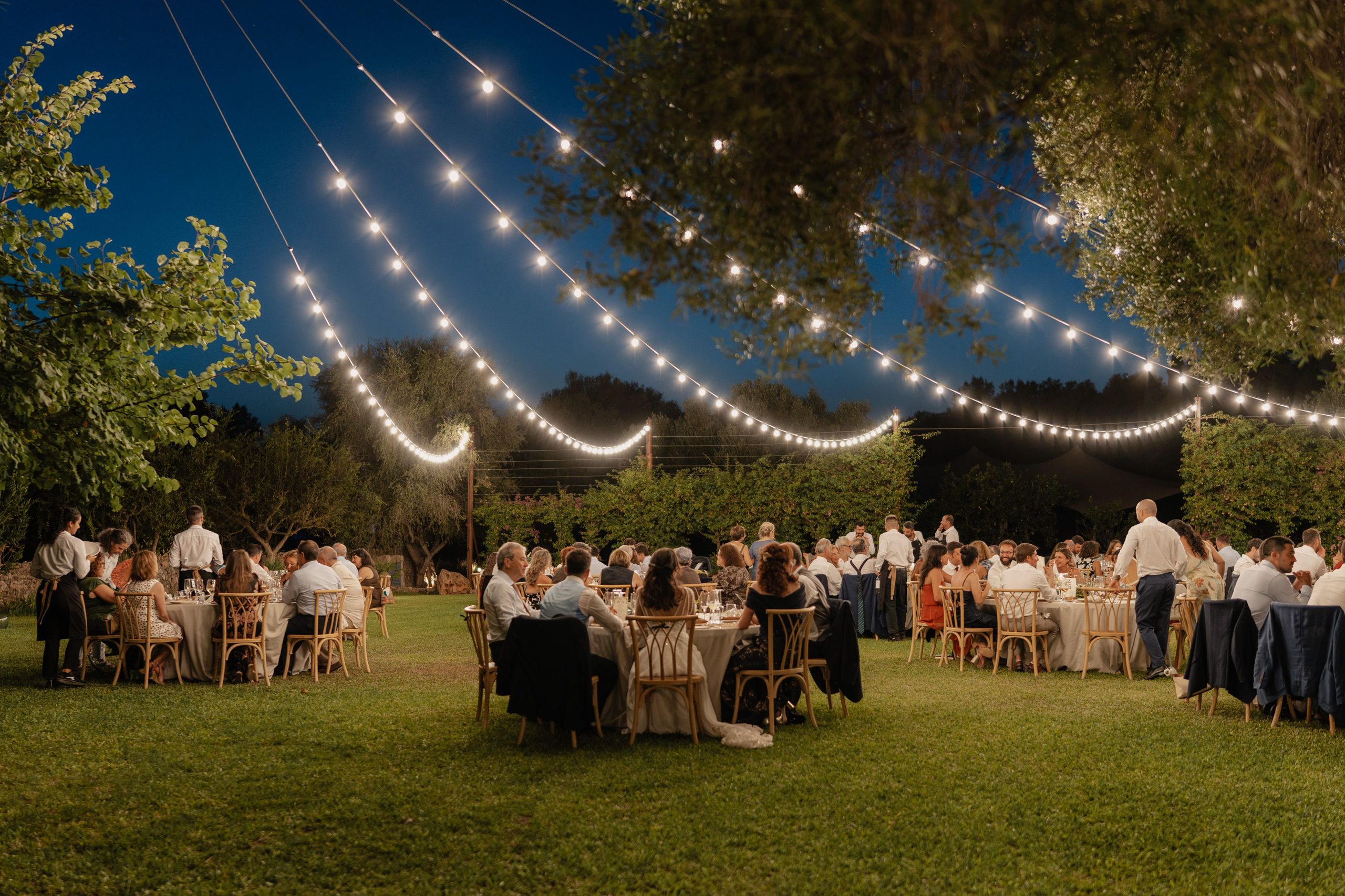 Dinner beneath strings of lights in the garden.