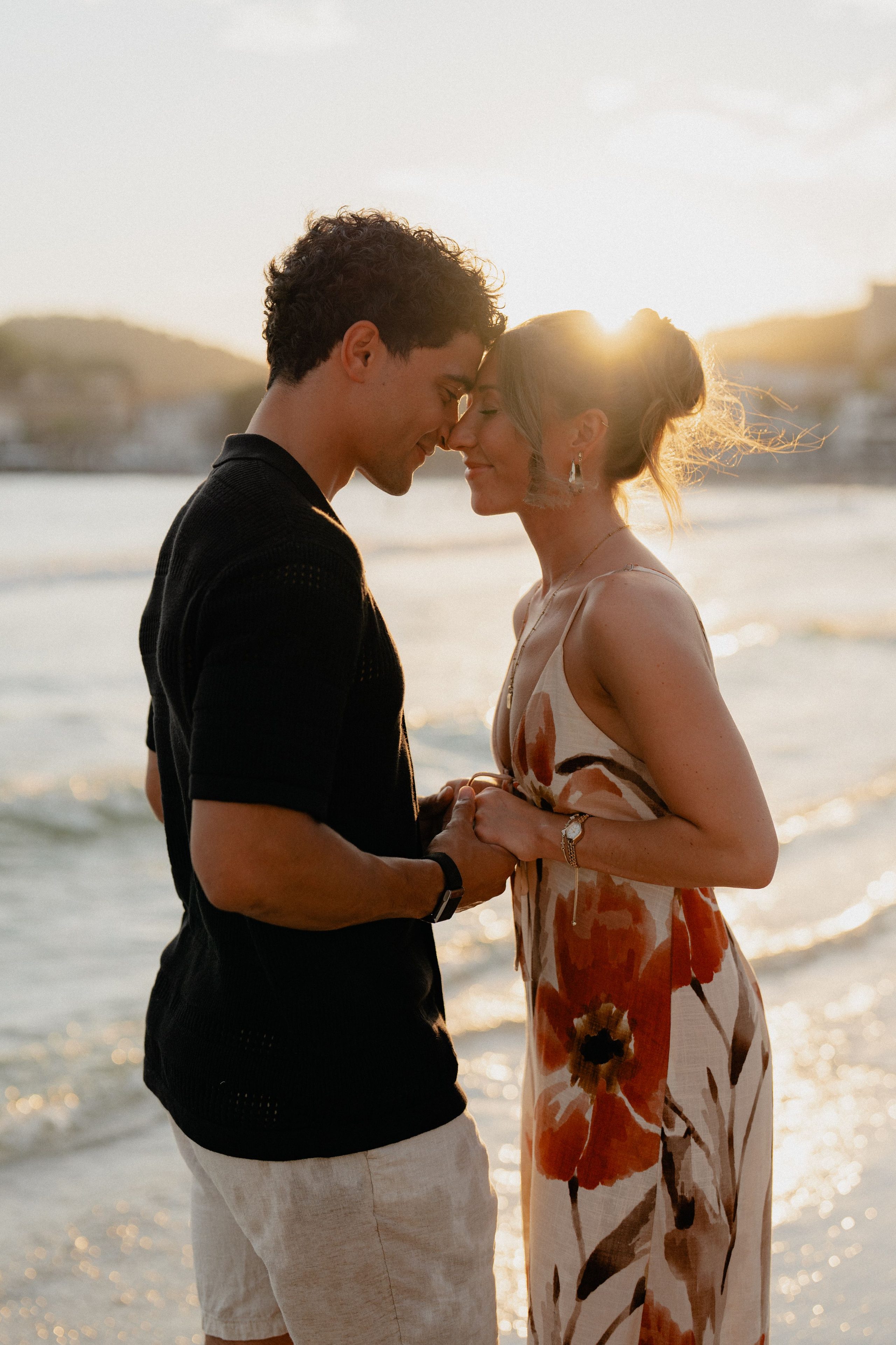 A couple together by the water at sunset.