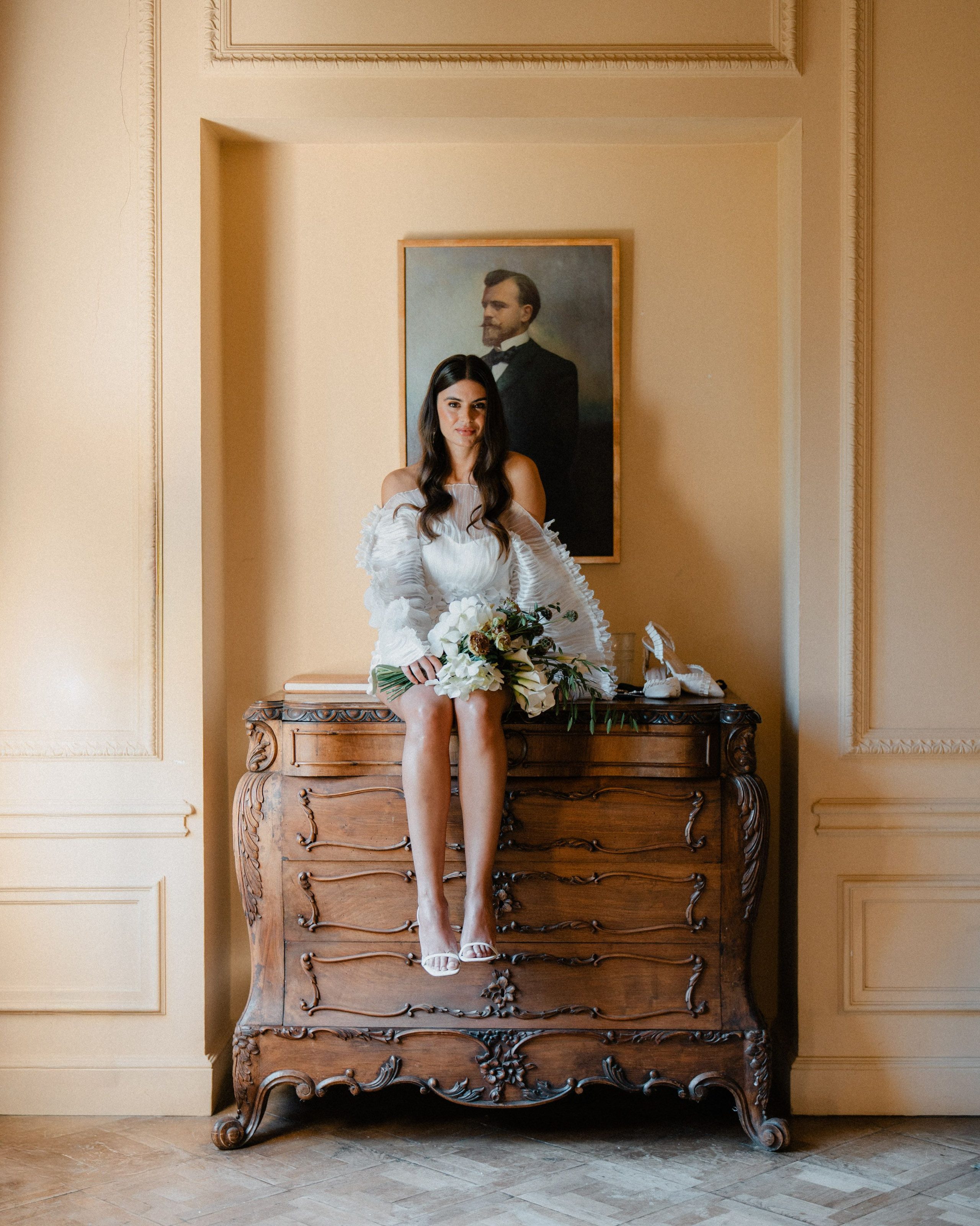 A couple's portrait in an elegant sunlit room.