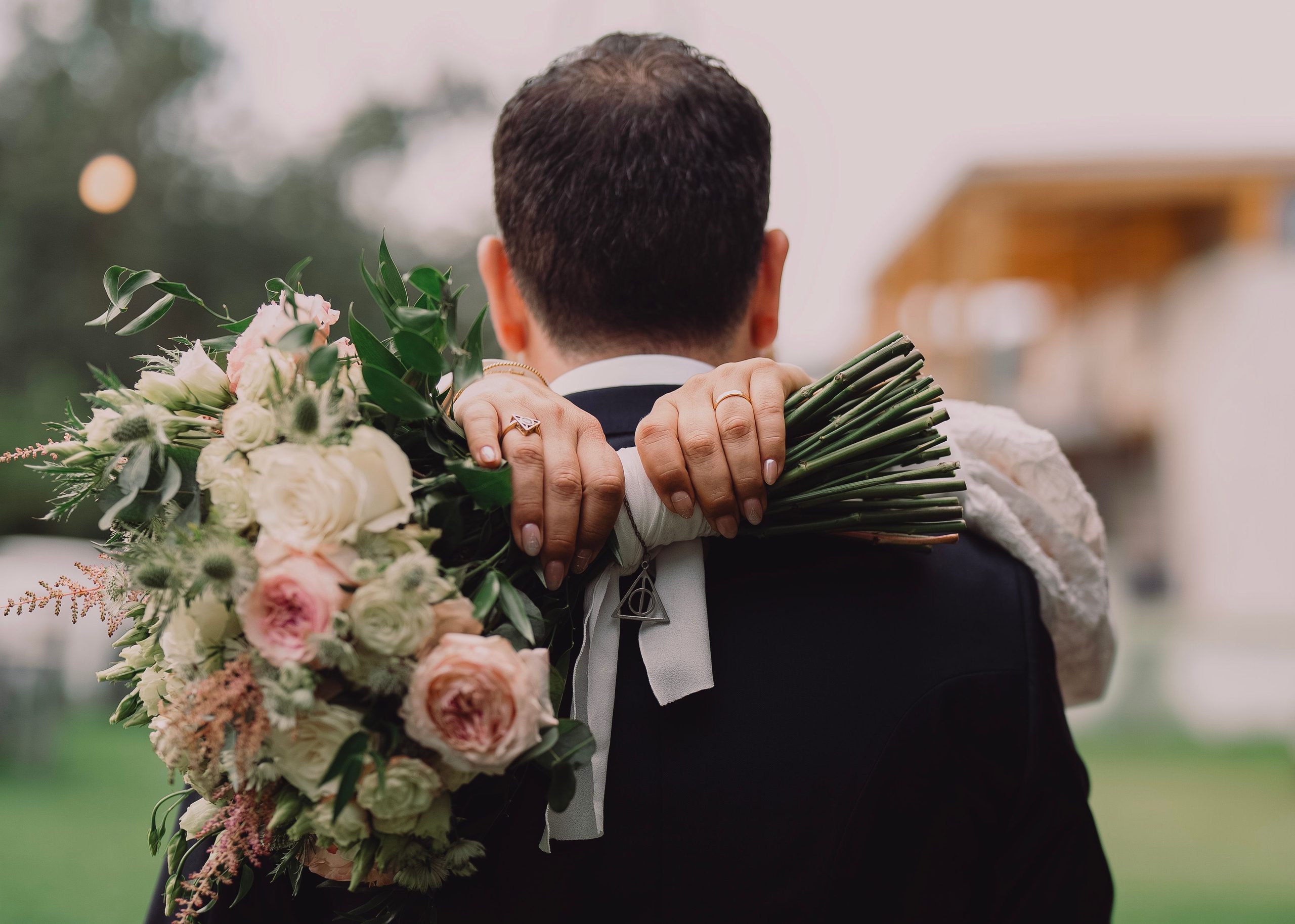 An embrace with the bouquet resting on a shoulder.