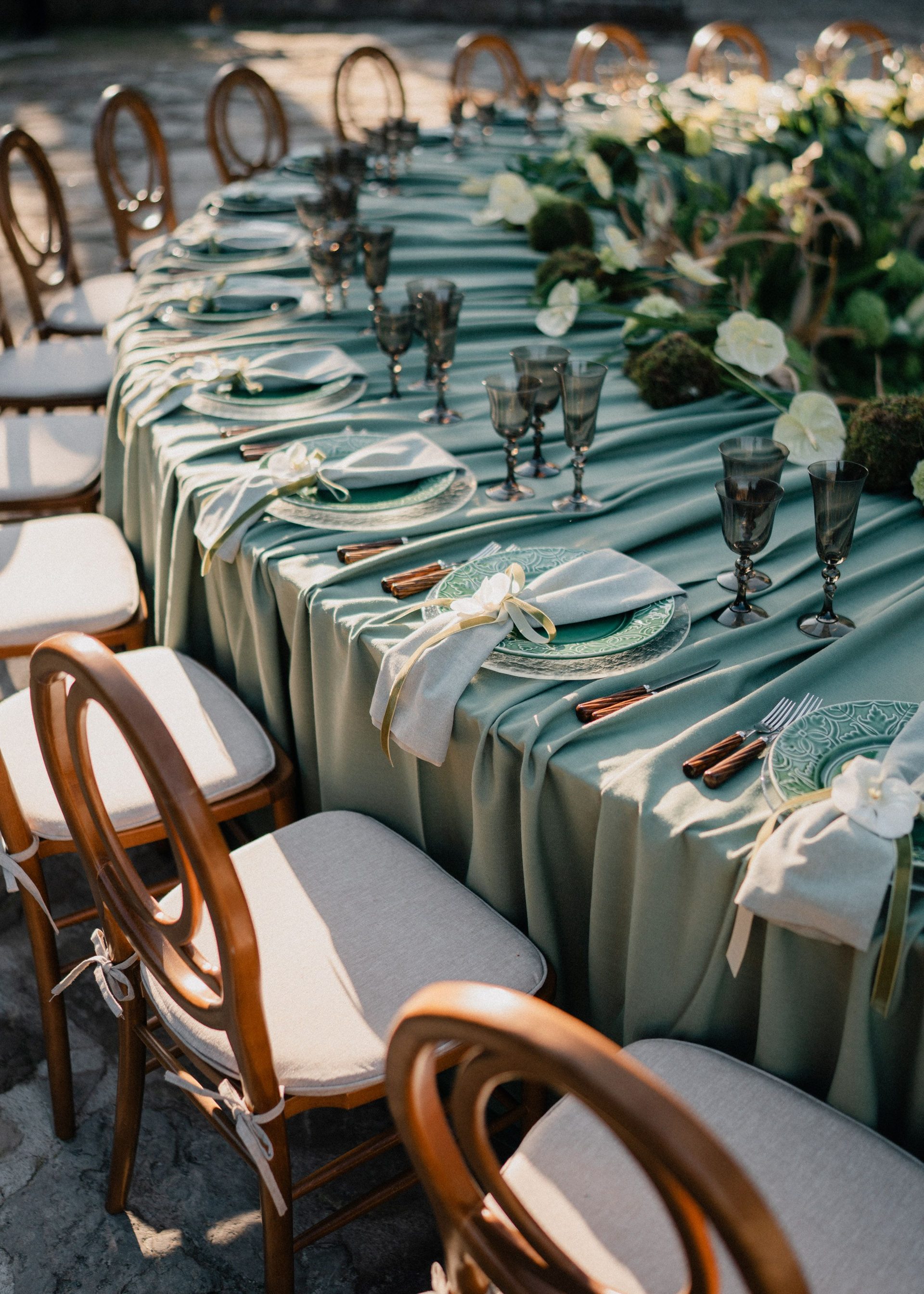 Flowers and glassware along a wedding table.