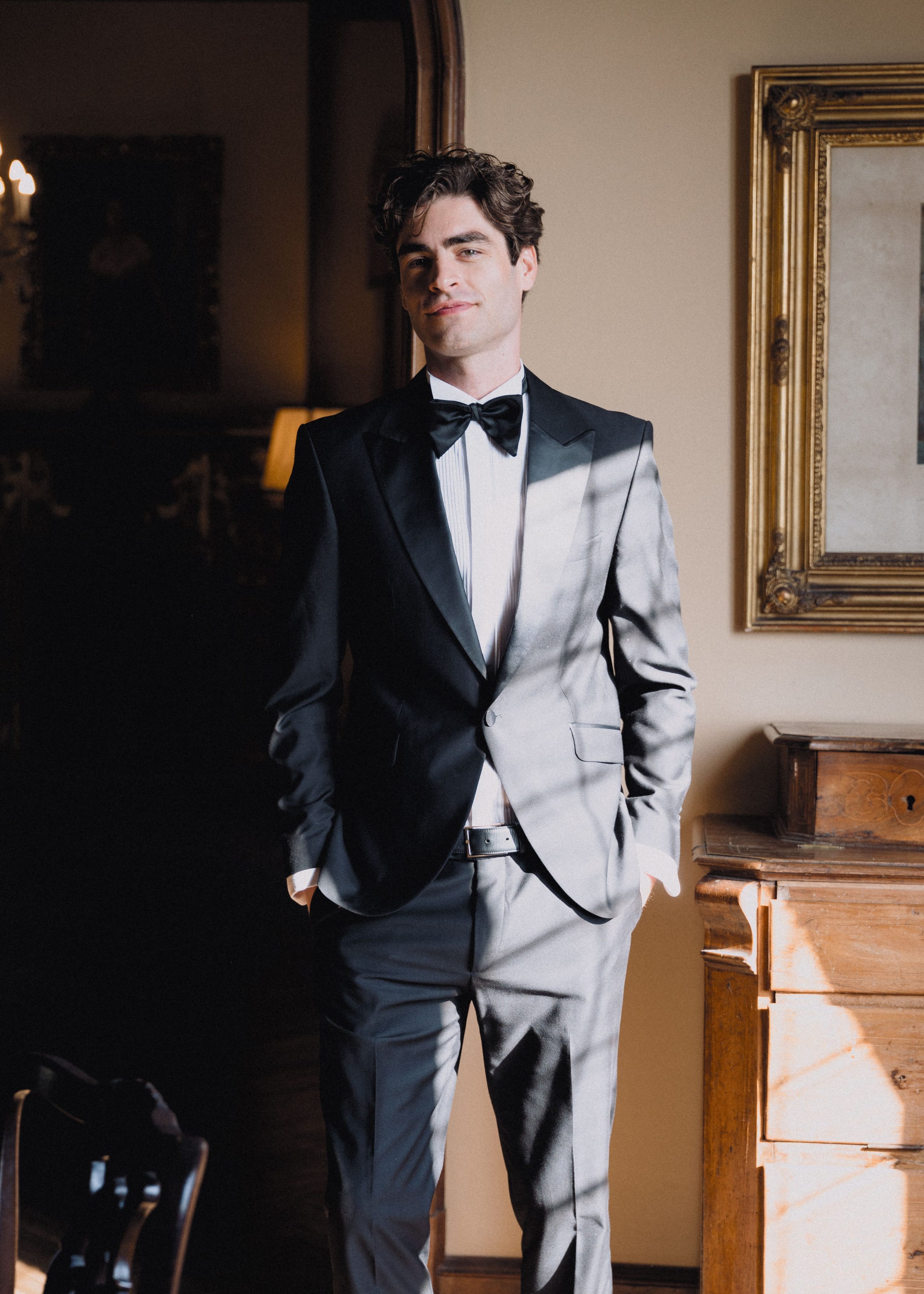 A groom's portrait in the light of a doorway.