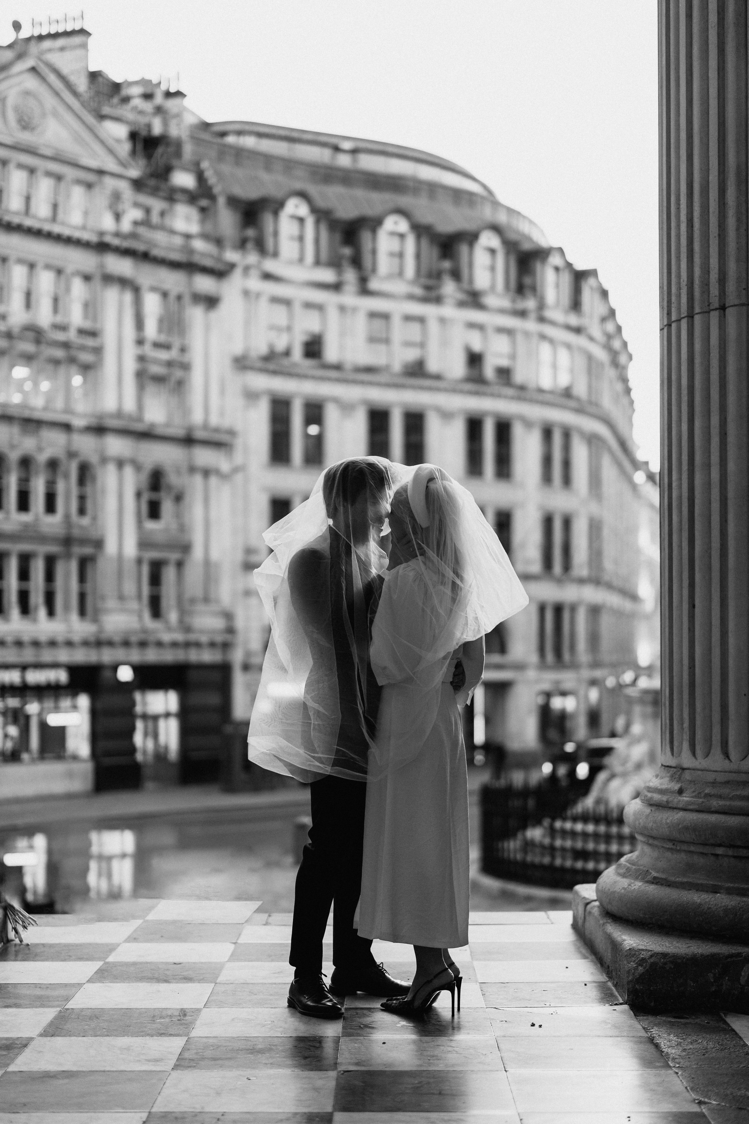 A black-and-white kiss on a city terrace.